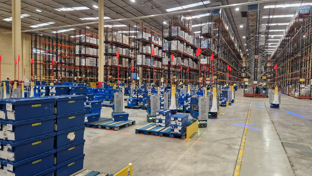Eine Flotte mobiler Locus-Roboter kommissioniert in einem von DHL betriebenen Distributionszentrum für den Großhändler Makro nahe Madrid. Auf unveränderter Fläche stieg der Durchsatz pro Mitarbeitendem dort von 50 auf 110 Auftragspositionen pro Stunde. - Bild: Locus Robotics