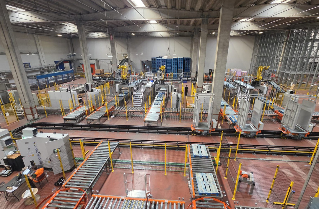 Automatisches Transportfahrzeug zum Verteilen von Paletten von den Palettierstationen zu den Folierstationen. - Bild: Interroll Holding GmbH