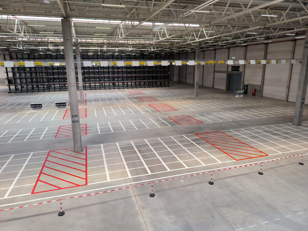 Für die eindeutige Identifikation der mehreren Tausend Stellplätze in Blocklagern hat Onk rund 3.500 barcodierte Schildern von der Hallendecke abgehängt – mittels einer speziellen Konstruktion über circa sieben Kilometer Länge. So lassen sich die Stellplatzkoordinaten aus weiter Entfernung lesen bzw. scannen – auch, weil die Profile der Schilder zusätzlich abgewinkelt sind. - Bild: Onk