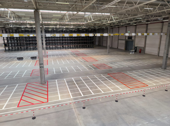 Für die eindeutige Identifikation der mehreren Tausend Stellplätze in Blocklagern hat Onk rund 3.500 barcodierte Schildern von der Hallendecke abgehängt – mittels einer speziellen Konstruktion über circa sieben Kilometer Länge. So lassen sich die Stellplatzkoordinaten aus weiter Entfernung lesen bzw. scannen – auch, weil die Profile der Schilder zusätzlich abgewinkelt sind.