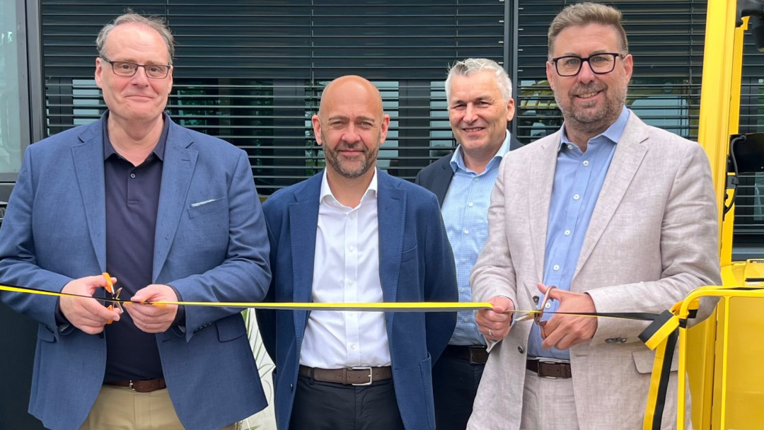 Experience Center in Mörfelden-Walldorf eingeweiht. Links Steward Murdoch (Geschäftsführer Hyster-Yale Deutschland GmbH und rechts Karsten Groß (CDU), Bürgermeister von Mörfelden-Walldorf an der Schere. Mitte links Vince Cooke (VP Sales – EMEA and Global Major Accounts) und Claus Herting, Area Business Manager Central and Eastern Europe, Turkey. - Bild: Hyster-Yale Deutschland
